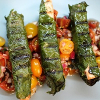 Image of Grilled Fish Wrapped in Grape Leaves with Cherry Tomatoes