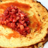 Image of ricotta cheesecake with macerated balsamic strawberries.