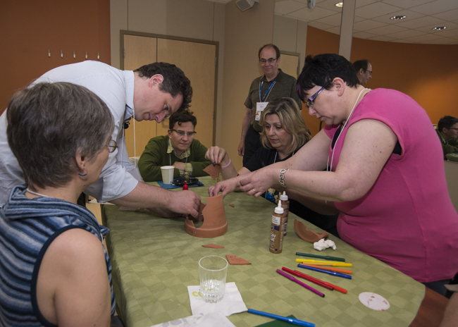 Image of a group of people reassembling a broken pot