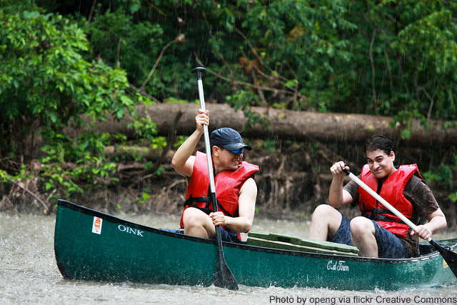 Image of two men in dark green canoe