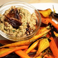 Image of A plate of white bean hummus with caramelized onions surrounded by honey roasted carrots 