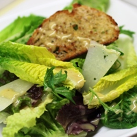Image of mixed green with creamy Caesar dressing. 