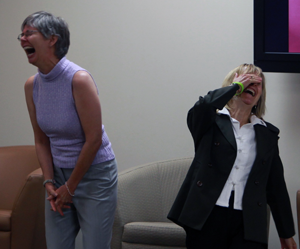 two women laughing so hard that they're near tears during a laughter class