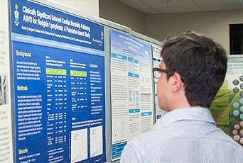 A man looks at a research poster